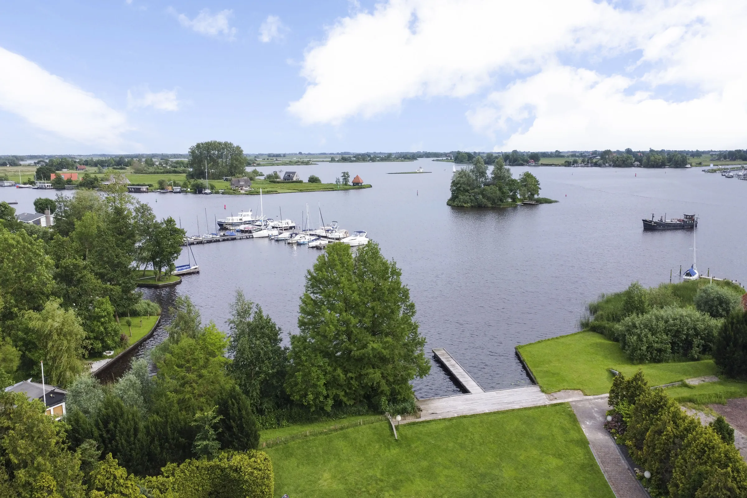 Luchtfoto van het meer bij het vakantiepark, met een jachthaven en een eilandje