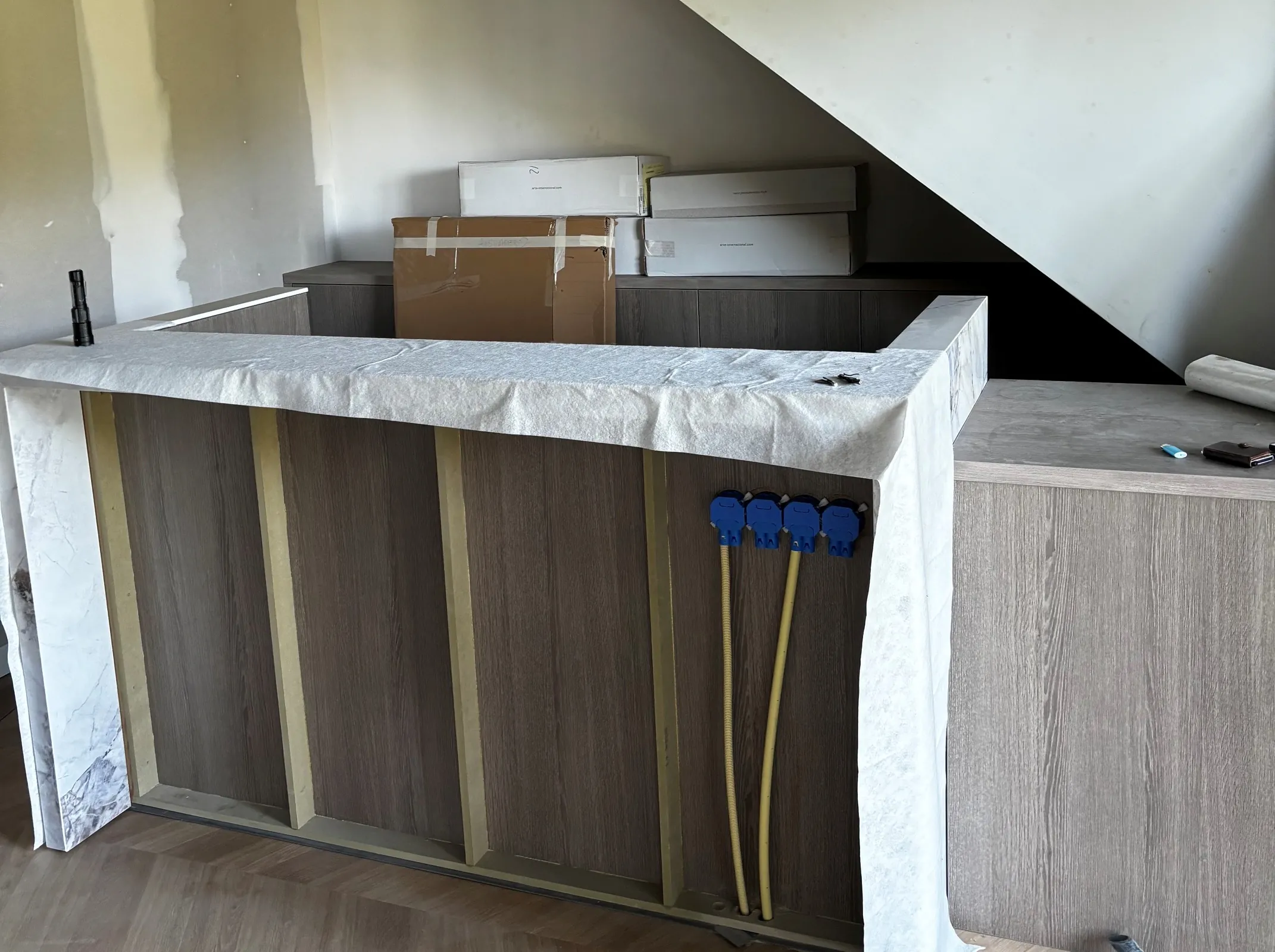 De bar in aanbouw onder de trap, het blad nog afgedekt met beschermvlies