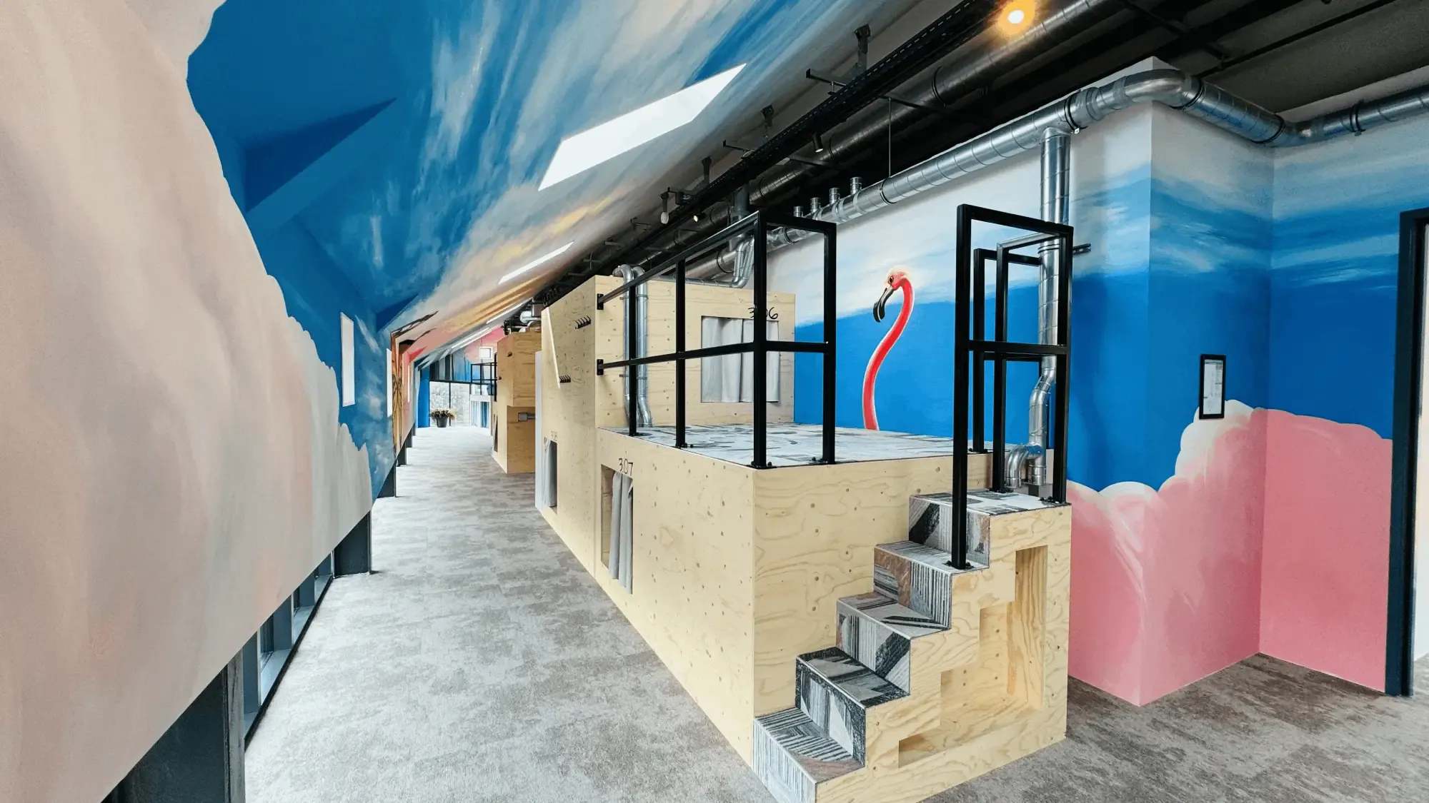 Houten slaappods met een trapje, een flamingo en wolken op de muur