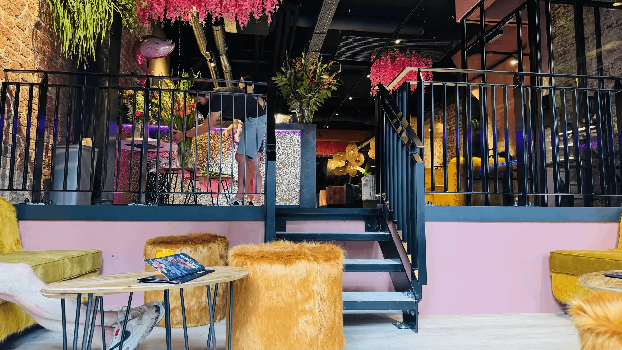 Een trap naar de verhoging, met fluffy poefs en roze wanden