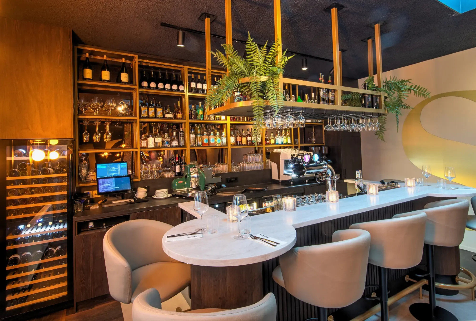 De opgeleverde bar van Sondrio in Drachten, met wijnkasten, groen boven de bar en een wit blad