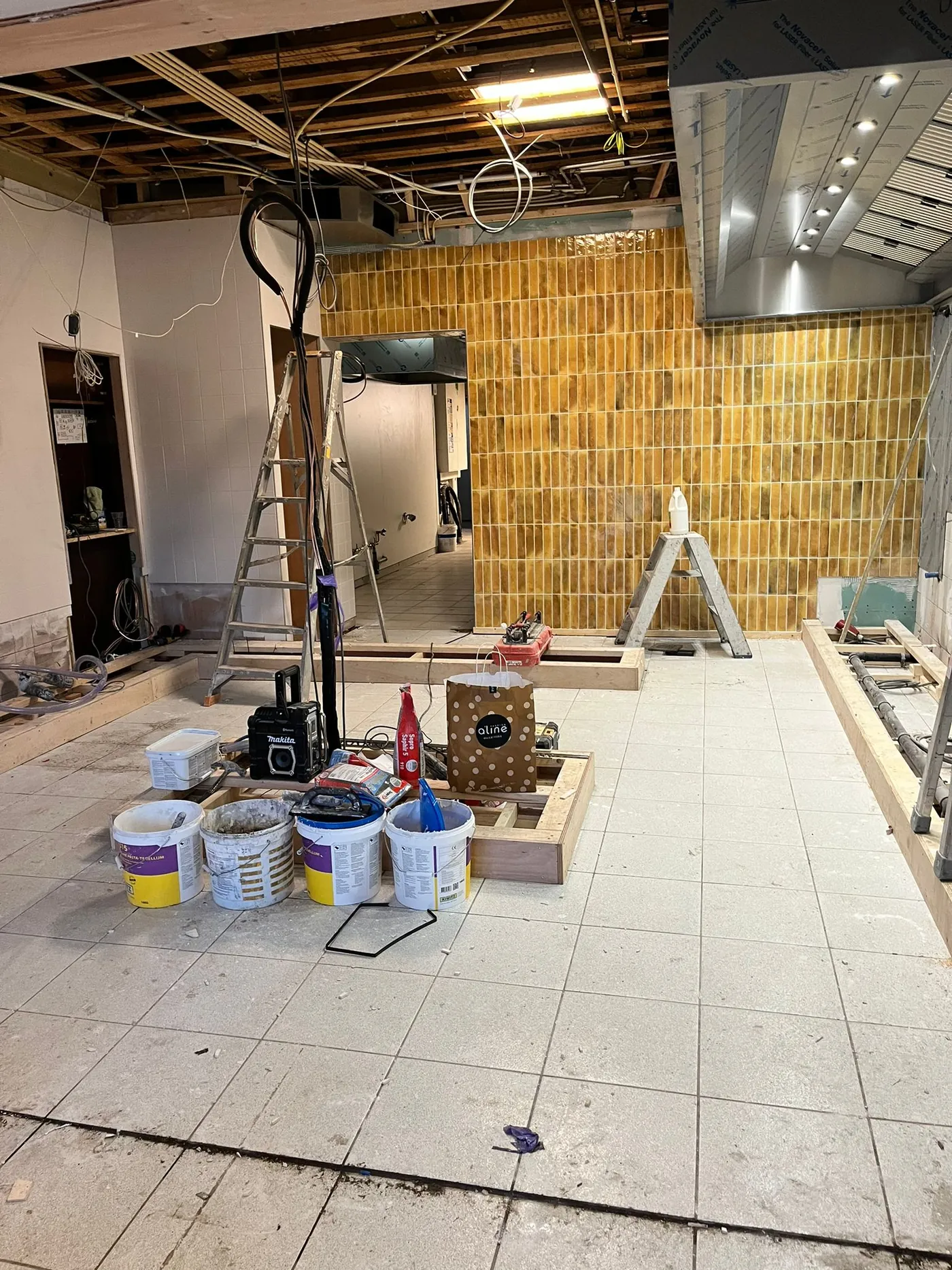De snackbar in aanbouw, met de nieuwe tegelwand en bouwmaterialen op de vloer