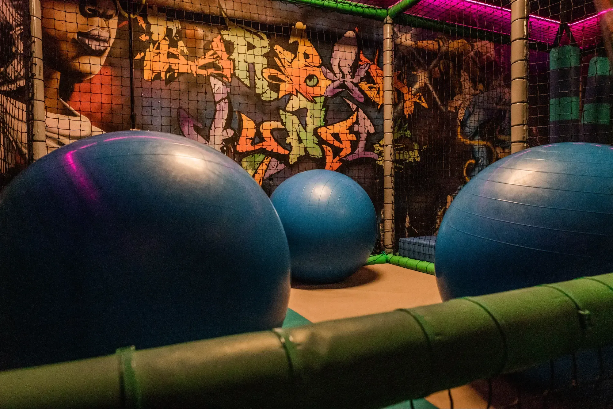 De speeltuin met grote blauwe ballen en een muurschildering op de achtergrond