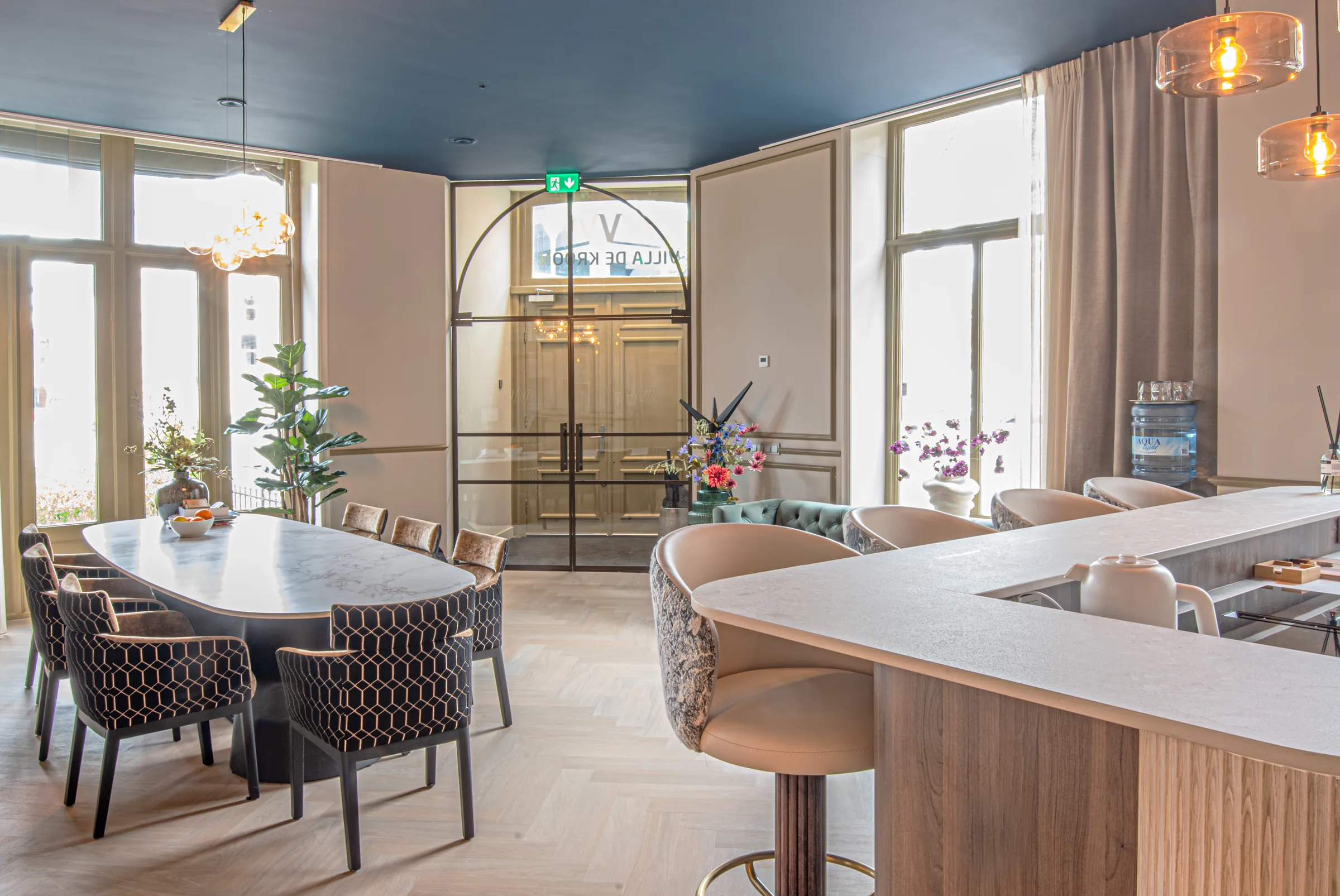 De lounge met eettafel en bar, gezien vanaf de bar met een bloemrijke barkruk op de voorgrond
